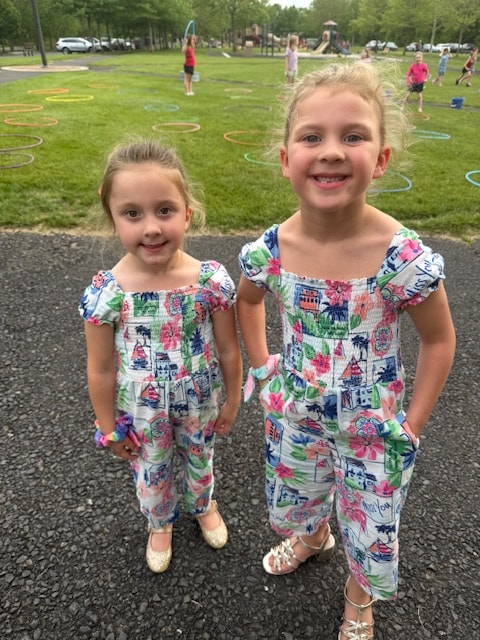 Two young Fitzpatrick dancers in red school shirts smiling together at a park