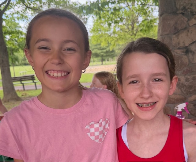 Four young Fitzpatrick dancers in red school shirts posing together on the grass