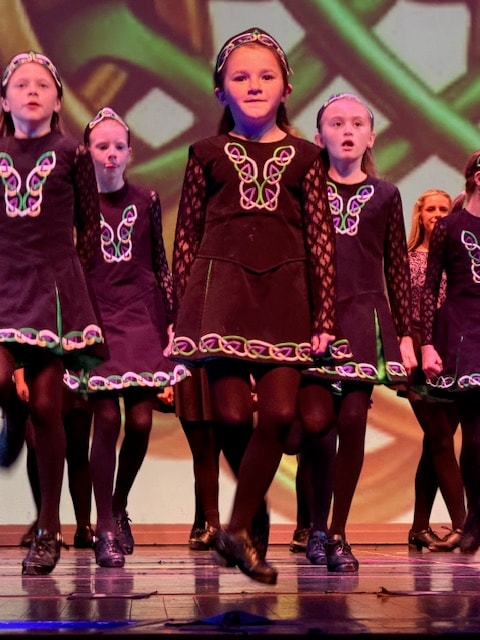 Fitzpatrick School Irish dancers performing on stage in traditional costumes