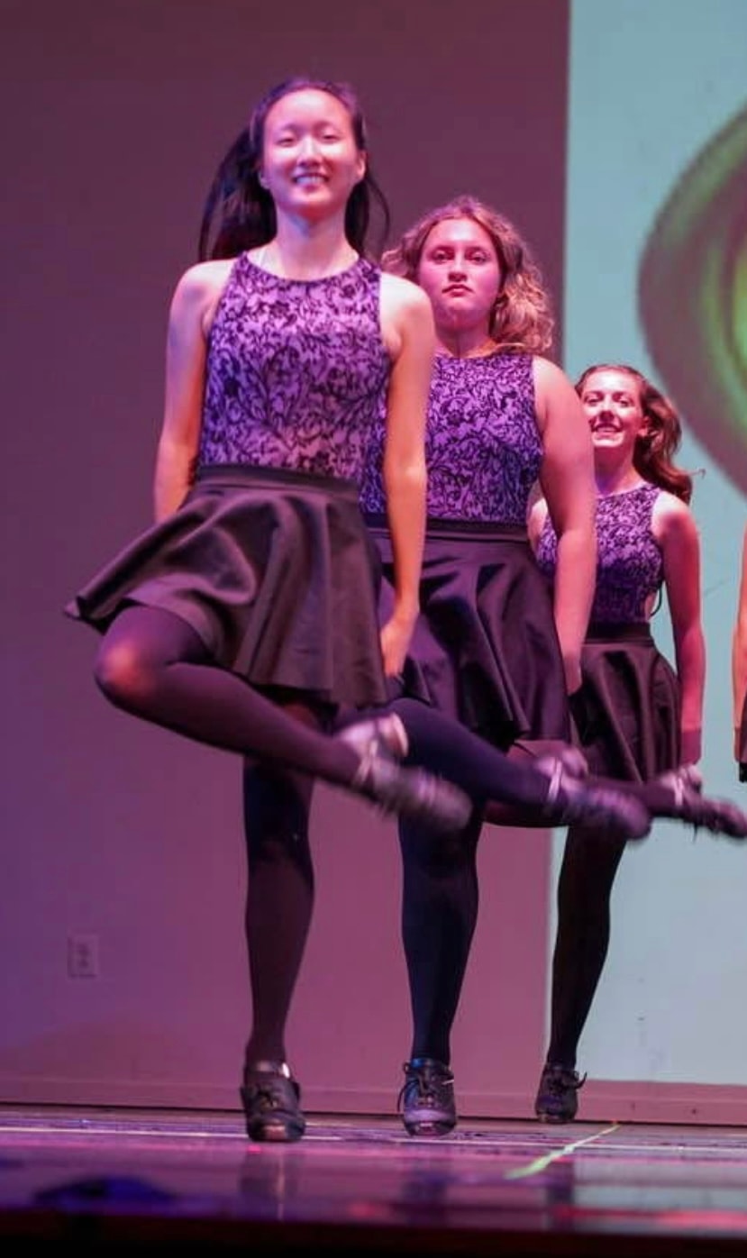 Fitzpatrick dancers in purple costumes performing on stage