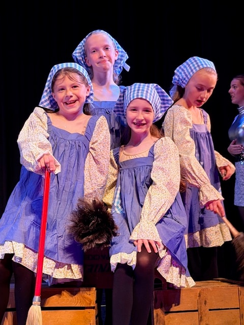 Dancers in costume smiling during the Miss Hannigan dance show