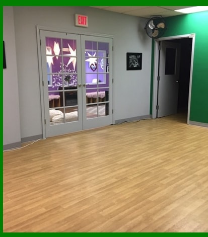 Dance studio floor with French doors looking into the purple lobby