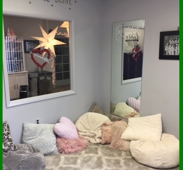Cozy studio lounge area with floor pillows, mirror, and inspirational wall quote